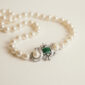 collar de perlas con broche de esmeraldas